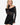 Model wearing black off-the-shoulder stretch lace top with long sleeves, styled for an elegant, feminine look, studio background