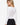 Model wearing white sweetheart neckline long sleeve knit top with seam detailing, styled for a chic, polished look, studio background