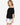 Model wearing white off-shoulder airflow dot top with puff sleeves and bow details, styled for a romantic, airy look, studio background