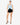 Model wearing powder blue halter neck open-back top with buckle detail, styled for a bold, chic look, studio background