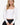 Model wearing white sweetheart neckline long sleeve knit top with seam detailing, styled for a chic, polished look, studio background