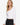 Model wearing white sweetheart neckline long sleeve knit top with seam detailing, styled for a chic, polished look, studio background