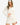 Model wearing white waffle knit bell sleeve top and skirt set, styled for a relaxed, feminine look, studio background