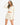 Model wearing white waffle knit bell sleeve top and skirt set, styled for a relaxed, feminine look, studio background
