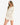 Model wearing white waffle knit bell sleeve top and skirt set, styled for a relaxed, feminine look, studio background