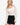 Model wearing off-white off-the-shoulder stretch lace top with long sleeves, styled for a chic, feminine look, studio background